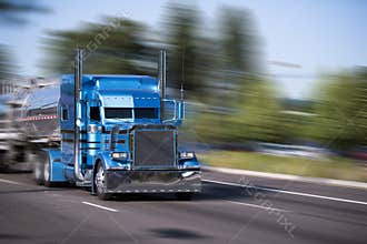 Impressive customized blue big rig semi truck with tank trailers