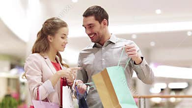 Happy young couple with shopping bags in mall