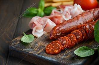 Chorizo sausage. Spanish traditional chorizo sausage and ham with fresh herbs and tomatoes.