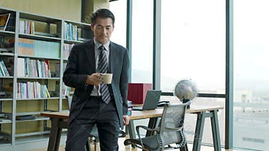 Asian corporate executive relaxing in office