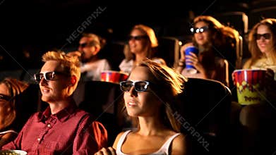 A group of excited young attractive happy male female friends enjoying 3d 4d action movie theater cinema eating popcorn