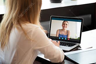 Two women chatting online by making video call on laptop