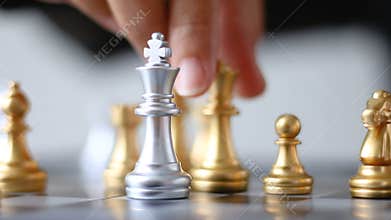 Close up shot hand of business woman moving golden chess to defeat a silver king chess on white and black chess board for business
