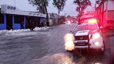 Policemen gard an area affected by the flood, the water flows on the sewers.