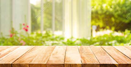 Empty wood table top on blur abstract green from garden
