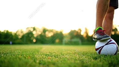 Close up legs and feet of football player in action wearing black shoes running and dribbling with the ball playing on
