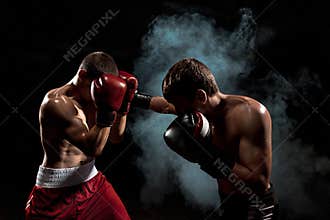 Two professional boxer boxing on black smoky background,