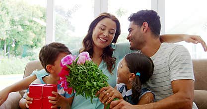 Happy family sitting on sofa and embracing in living room