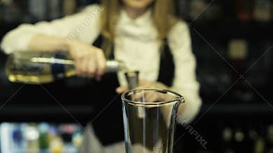 Bartender pours vodka in a glass