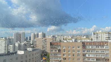 Drops of rain on a window pane, buildings in