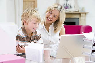 Woman and young boy in home office with laptop