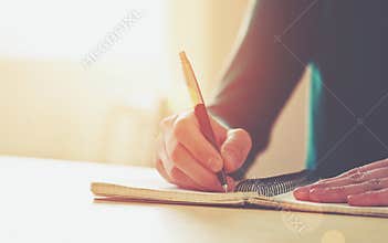 Female hands with pen writing