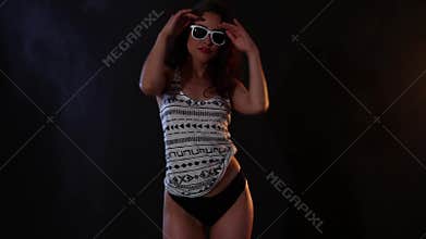 brunette woman in black bikini and white shirt dancing