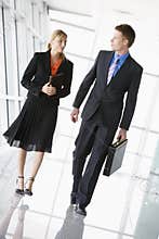 Two business people walking in corridor talking