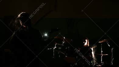 Vocalist and drummer of black metal band at dark background