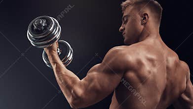 Handsome athletic man working out with dumbbells