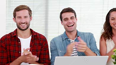Casual business team applauding during meeting