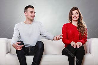 Shy woman and man sitting on sofa. First date.