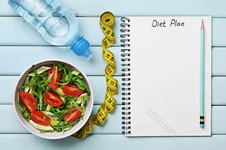 Diet plan, menu or program, tape measure, water and diet food of fresh salad on blue background, weight loss and detox concept