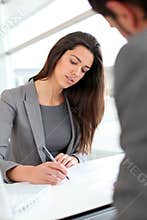 Businesswoman writing a document for partner