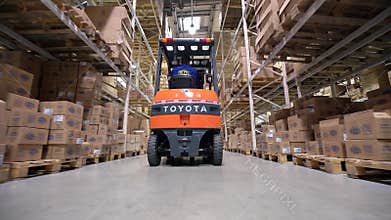 Forklift Trucks Move Between Large Metal Shelves