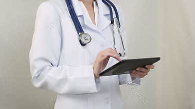 The doctor in a white coat working with the tablet.