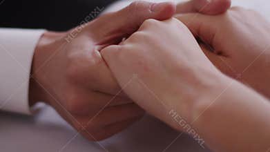 Close up of a young couple sitting at a table holding hand Shot on RED Digital Cinema Camera in 4K