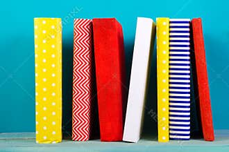 Stack of colorful books, grungy blue background, free copy space