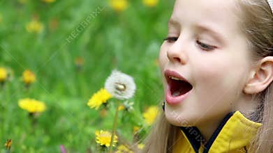 Child blowing on dandelion in park outdoor.
