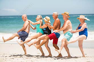 Seniors dancing in a row at the beach