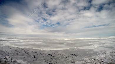 Research vessel in icy arctic sea on a sunny day