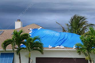 Storm damaged house with protective tarp