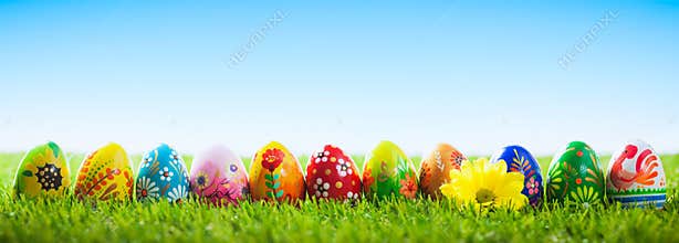 Colorful hand painted Easter eggs on grass. Banner, panoramic