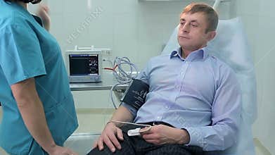 Nurse measuring blood pressure to a patient