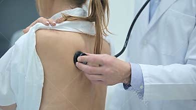 Doctor examining patient with stethoscope
