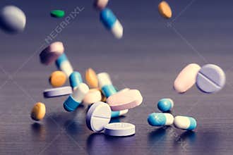 Pharmacy background on a dark table. Levitation pills. Tablets on a dark background which falling down. Pills. Medicine and health