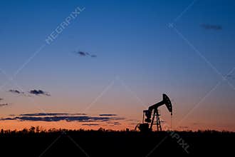 Oil well pumpjack sunset silhouette