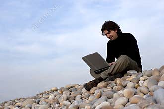 Young man with laptop computer in the outdoors