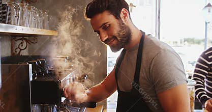 Smiling waiter making cup of coffee