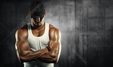 Strong man posing on a concrete background