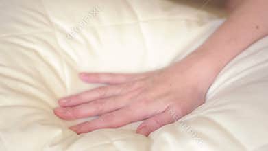 Female hand pressing on the pillow. soft pillow