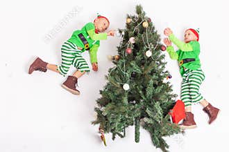 Flying little elves decorating Christmas tree. Santa's helpers
