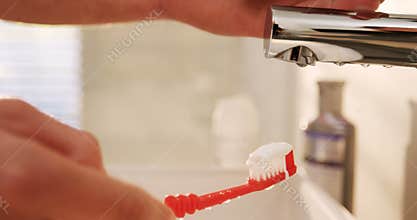 Man putting toothpaste on toothbrush