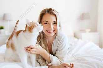 Happy young woman with cat in bed at home