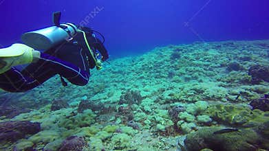 Underwater shoot of a scuba divers swimming in blue clear water.