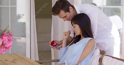 Romantic young man proposing to his girlfriend