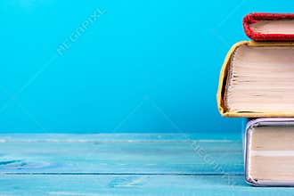 Stack of colorful books, grungy blue background, free copy space