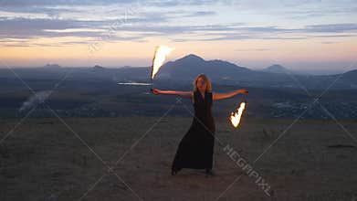 Woman twirling burning torch
