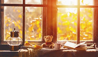 Fall. cozy window with autumn leaves, book, mug of tea
