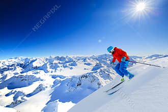 Ski touring man reaching the top in Swiss Alps.